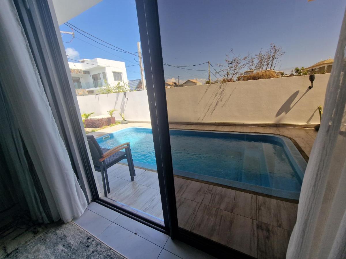 Pool view from bedroom at Luxora Villa Grand Baie